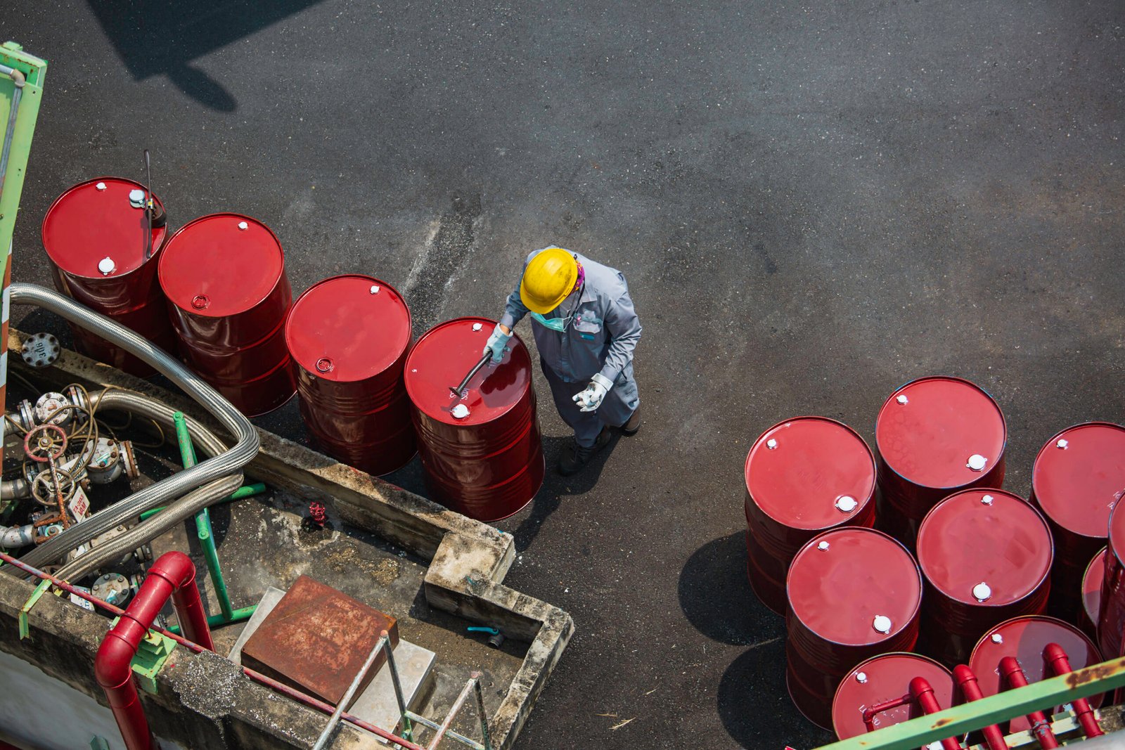 Top view male worker inspection record drum oil stock barrels red vertical or chemical for in the industry.